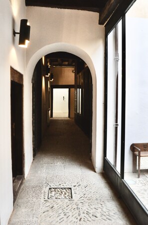 Ein Flur mit gewölbter Decke, einer Bank und einer Tür am Ende.