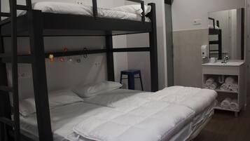 A bunk bed room with a small stool, a sink, and a mirror.