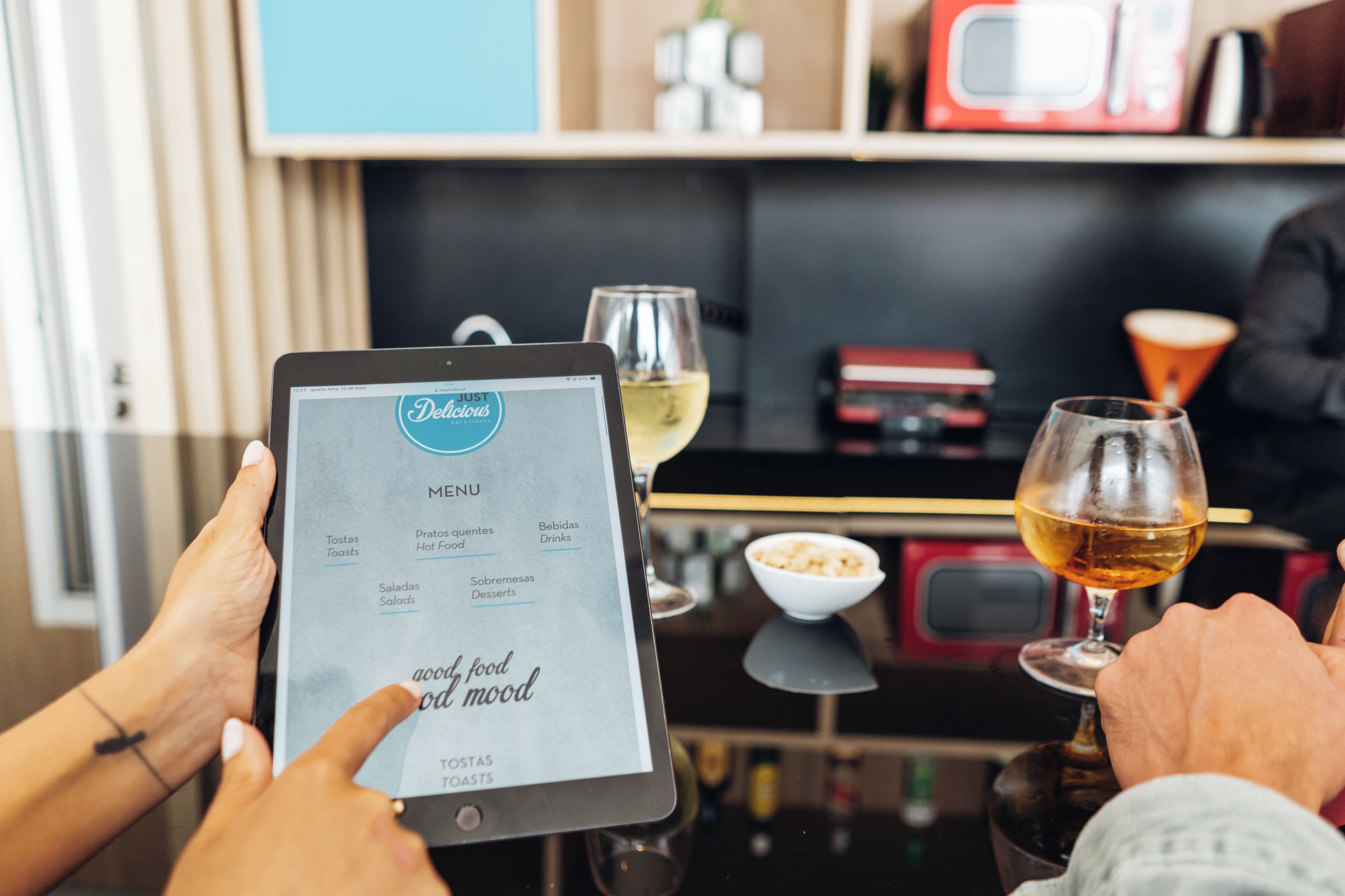 A tablet displaying a menu with options like 'Tostas Toasts' and 'Saladas Salads'.