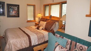 A bedroom with a bed, a nightstand, a lamp, and a window. - 24 Little Ln (Snowmass Village)