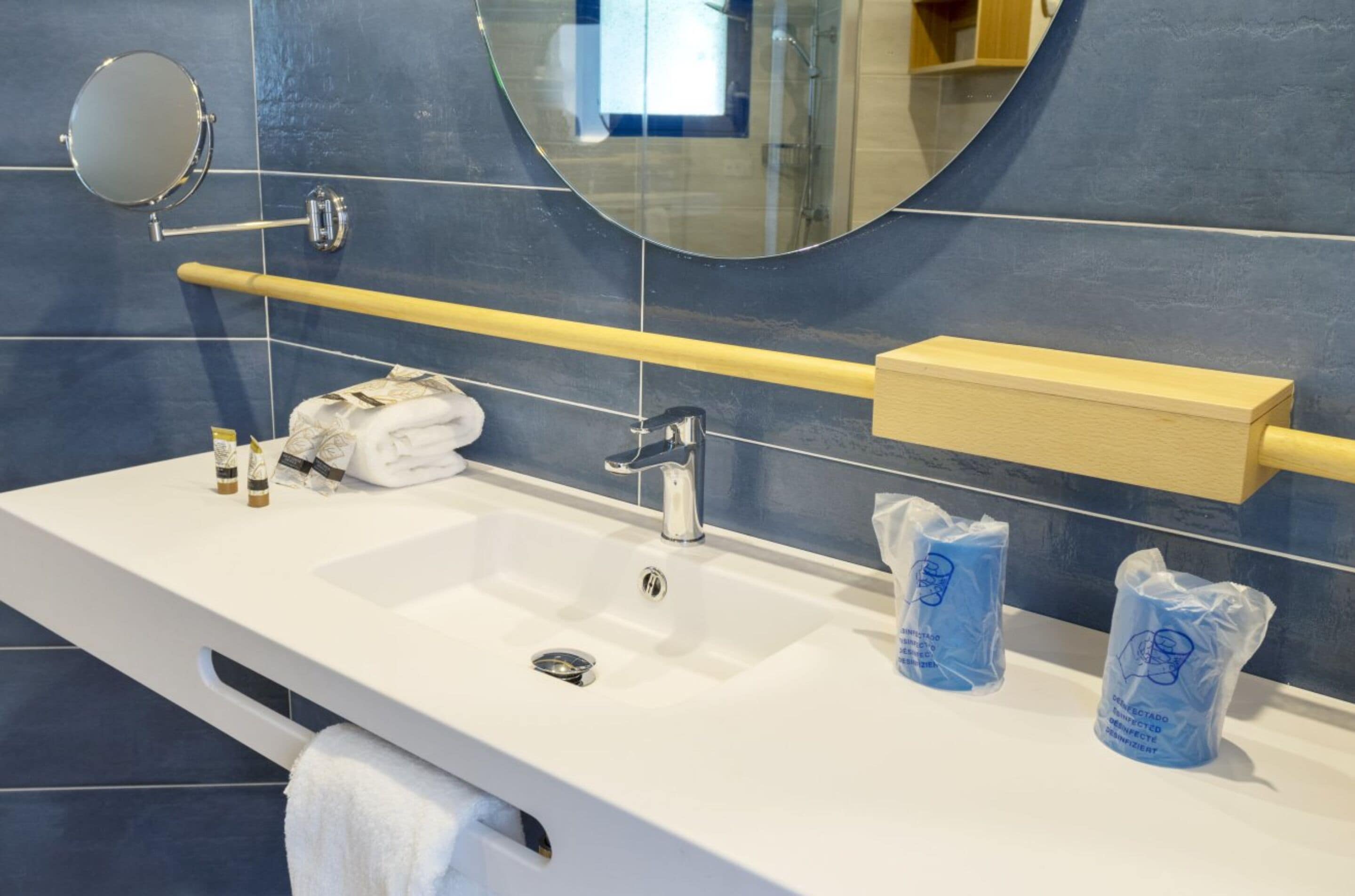 A bathroom with a white sink, a mirror, and a towel rack.