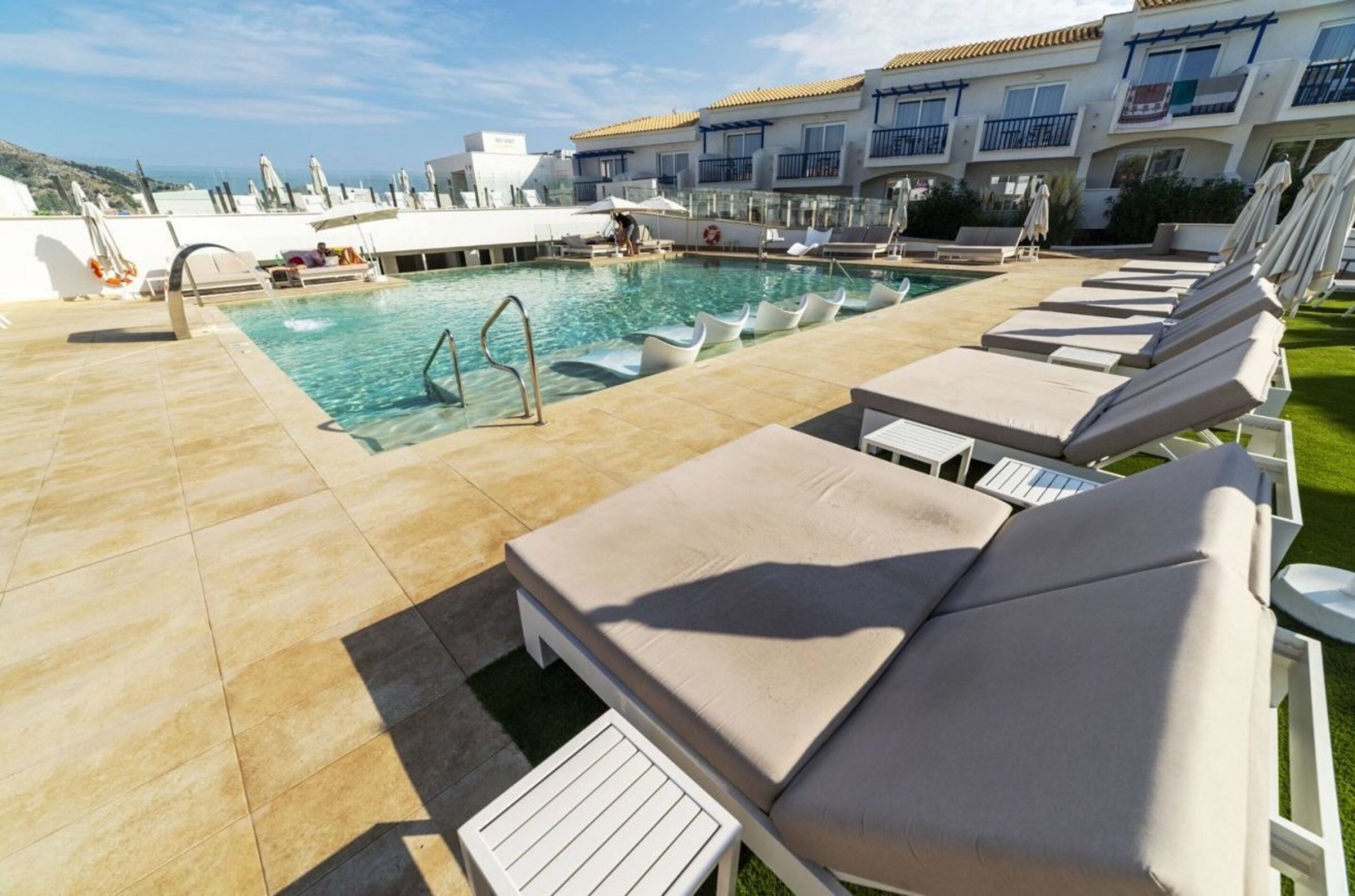 A pool area with lounge chairs and a swimming pool.