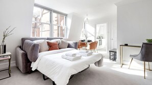 A modern bedroom with a large bed, a desk, and a chair. - The Wellington Suite next to Sloane Square (London)