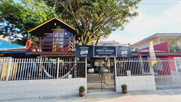 Ein Hotel Eingang mit einem Schild für 'Open House Lounge Bar' und 'Pousada Boutique'.