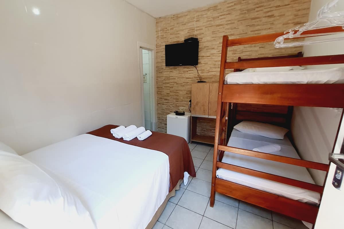 Ein Hotelzimmer mit zwei Betten, einem Fernseher und einem Holzbettkasten.