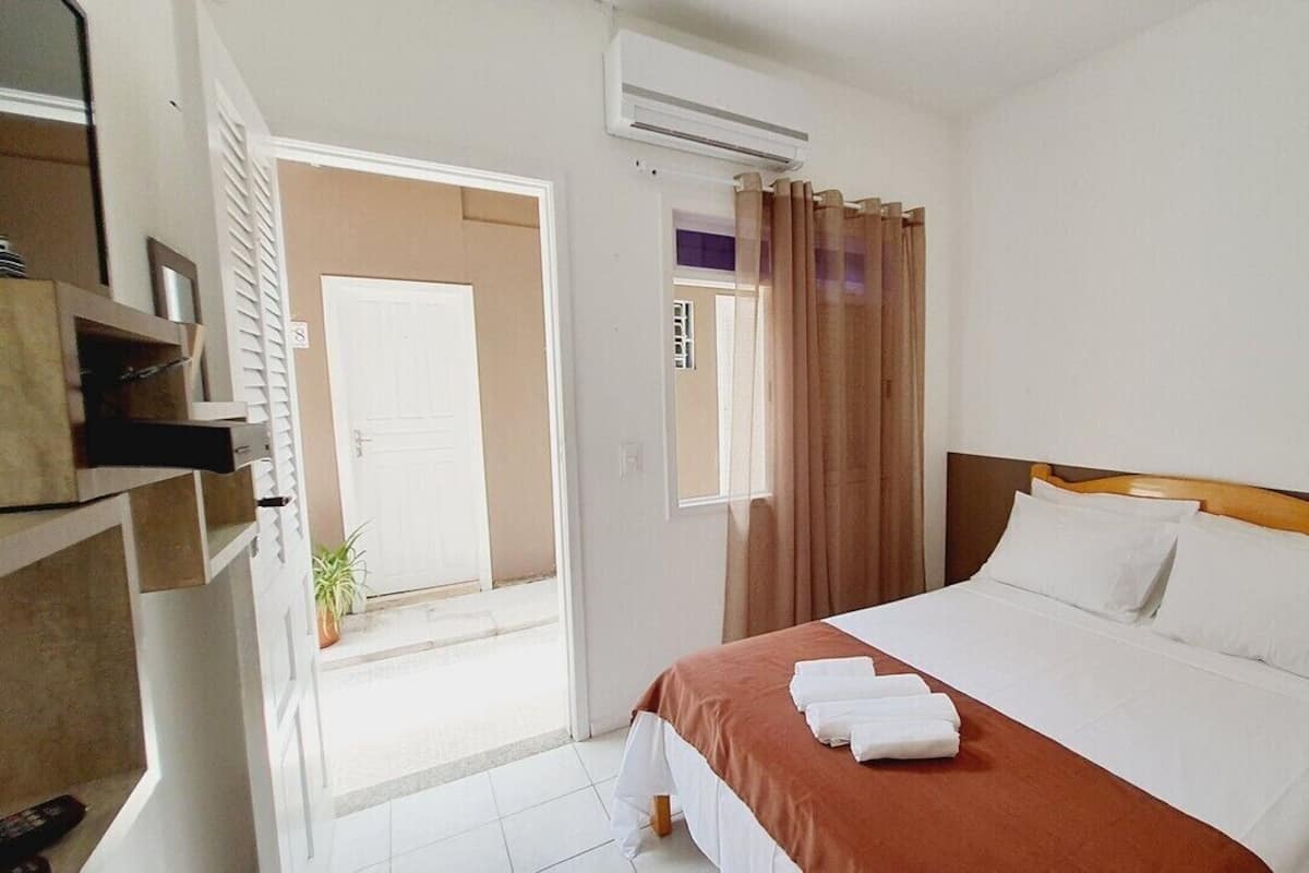 Ein Hotelzimmer mit Bett, Bad und Zugang zu einem Außenbereich.