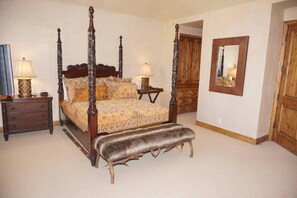 A four-poster bed with a bench, two bedside tables, and a mirror on the wall. - 381 Ridge Rd #C1 (Snowmass Village)