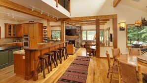A spacious kitchen with wooden cabinets, a bar area, and a dining area with a large table and chairs.