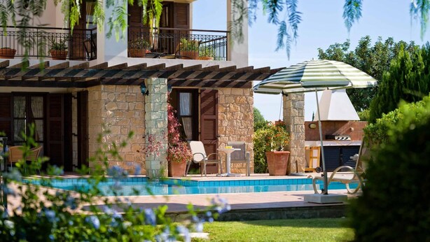 A two-story building with a stone facade, a pool, outdoor seating, and a barbecue area. - Villa 64 Anarita - Three Bedroom Villa, Sleeps 6 (Kouklia)