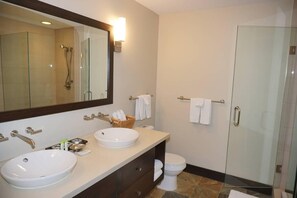 A modern bathroom with two sinks, a large mirror, a glass shower enclosure, and a toilet. - 120 Carriage Way (Snowmass Village)