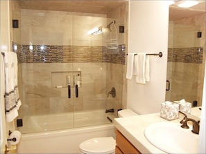 A modern bathroom with a glass-enclosed shower, a white sink, and a toilet. - 733 Francis St W (Aspen)