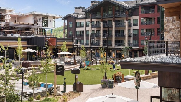 Un hôtel moderne à plusieurs étages, doté d’espaces extérieurs aménagés et d’une cour intérieure.