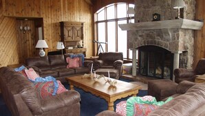 Ein gemütliches Wohnzimmer mit Ledersofas, einem Holztisch und einem Steinkamin.