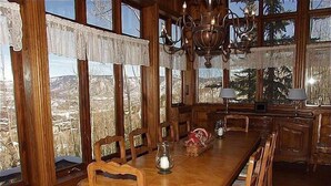 Ein Essbereich mit einem langen Holztisch, Stühlen und einer Chandelier.