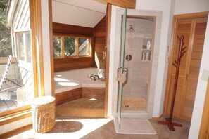 A bathroom with a glass-enclosed shower, a bathtub, and a large window. - 735 Bleeker St E #735 (Aspen)