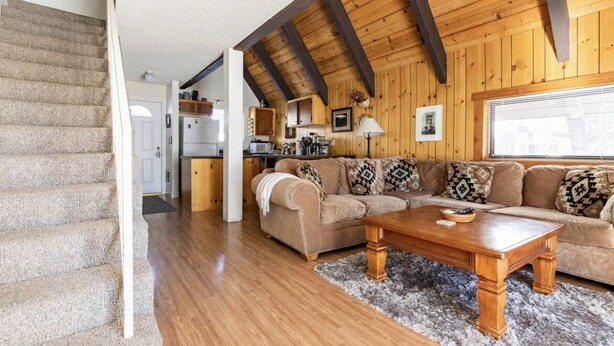 A spacious living area with a wooden ceiling, a sofa set, and a coffee table.