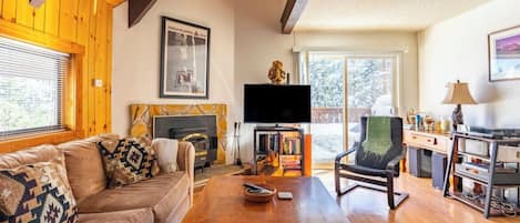 A cozy living room with a fireplace, a television, and a comfortable seating area.