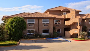 A multi-story building with a tiled roof, multiple windows, and a central staircase.