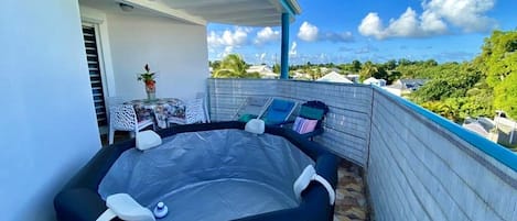 Un jacuzzi en un balcón con vistas despejadas del entorno.