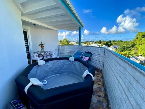 A hot tub on a balcony with a clear view of the surrounding area. - Quiet and spacious APT, with balcony, 5min from beach (Sainte-Anne)