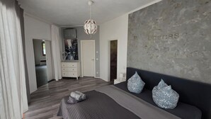 Un dormitorio con cama, cómoda, armario y pared con diseño texturizado.