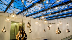 Un interior moderno con diseño geométrico en el techo y lámparas colgantes.