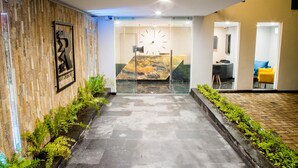 Un interior moderno con una pared de piedra, un reloj y una silla amarilla.