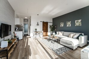 Enjoy a spacious living area with a cozy seating arrangement and a modern kitchen.
