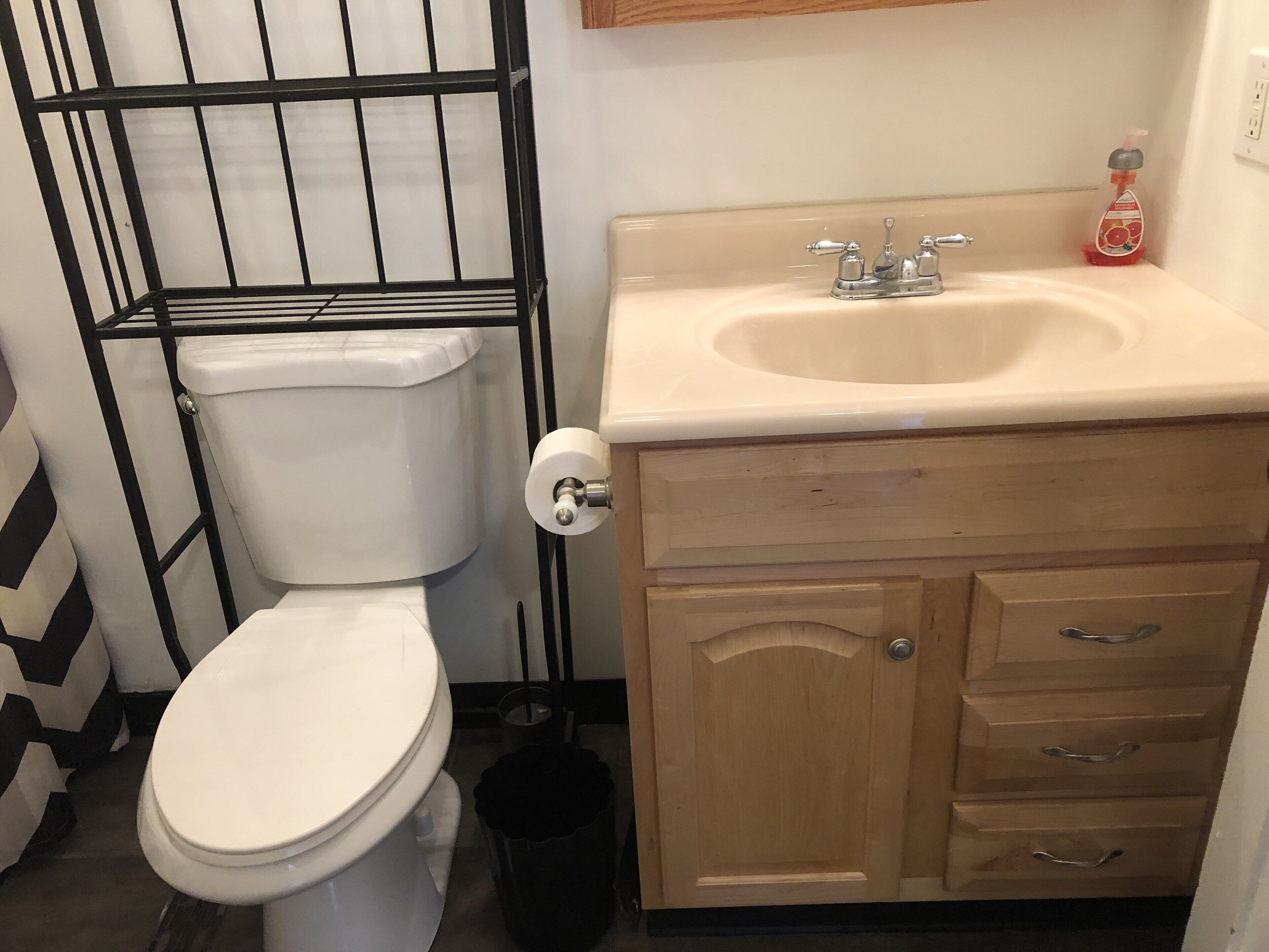 Une salle de bain avec des toilettes, un lavabo et des meubles en bois.