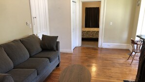 A living room with a grey sofa, a round wooden coffee table, and a wooden floor. - 1bedroom/1 bath      (Oneonta)
