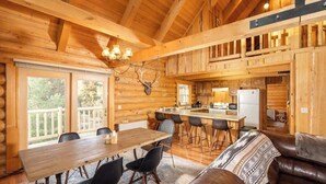 Ein rustikales Holzhaus-Interieur mit Essbereich, Küche und einer Ledersofa.