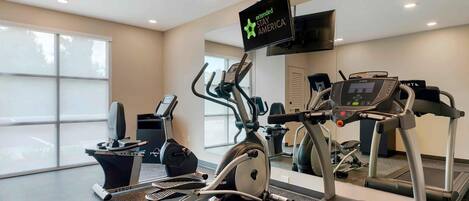 Ein Fitnessraum mit unterschiedlichen Trainingsgeräten, darunter Laufband, Crosstrainer und Ergometer.