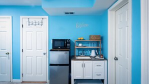 A compact kitchen with a microwave, refrigerator, and a small sink area. - Comfy Blue Studio with Great Amenities (Washington)