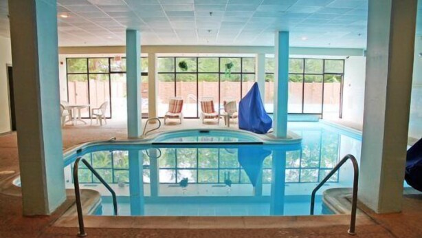 An indoor swimming pool with a view of the outdoors, surrounded by windows and chairs. - Silver Creek 1104  Studio Sleeps 3,  Slope Side (Snowshoe)