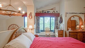 A bedroom with a large bed, a wooden dresser, a chair, and a mirror. - Silver Creek 5216 - The Winter`s Wonderland 2 Br Condo (Snowshoe)
