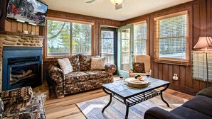A cozy living room with a patterned sofa, a fireplace, and a television mounted on the wall. - Tree Top 19, Snowpeak 2 Bedroom Spectacular Townhome Slope Side (Snowshoe)