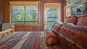 A wooden room with a bed, a chair, and a window with a view of trees. - Tree Top 19, Snowpeak 2 Bedroom Spectacular Townhome Slope Side (Snowshoe)