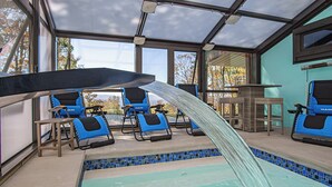 Un espace piscine extérieur abrité, avec des chaises bleues et un toboggan aquatique.