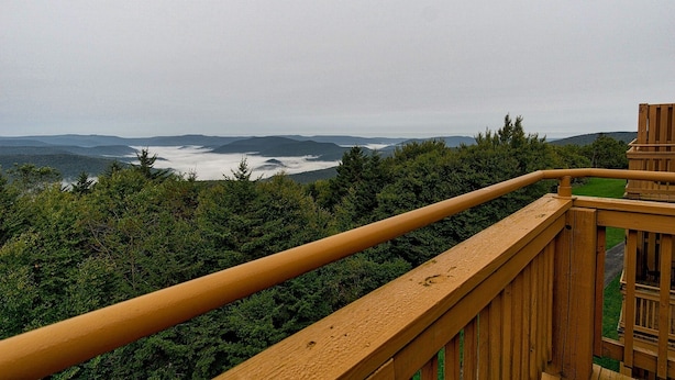 A wooden deck with a view of a forested valley and distant mountains. - Summit 304C, Snow White Summit 3 Br Walk to Slopes & Village (Snowshoe)