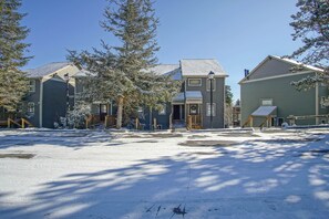 A residential area with houses, a clear sky, and snow on the ground.