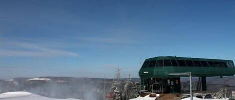A snow-covered landscape with a green building, possibly a lodge or facility, in the background.