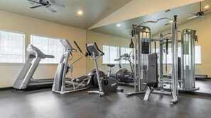 A gym with treadmills, elliptical machines, and weightlifting equipment. - Pinetop | Couples Mountain Retreat | Pool + Hot Tub (Pinetop)