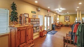 A lobby with a reception desk, a Christmas tree, a movie rental sign, and a clothing rack. - Pinetop | Couples Mountain Retreat | Pool + Hot Tub (Pinetop)