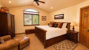 A bedroom with a large bed, wooden furniture, a ceiling fan, a window with blinds, and a rug. - 4BD Home  Private Hot Tub  Minutes to Slopes & Main St (Park City)