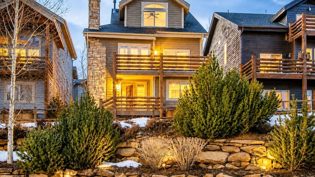 A multi-story log cabin with a stone chimney, wooden balconies, and a stone foundation. - 4BD Home  Private Hot Tub  Minutes to Slopes & Main St (Park City)
