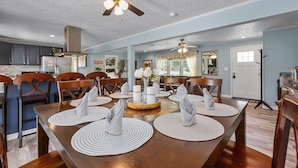 A dining area with a wooden table set for four, surrounded by chairs. A ceiling fan is visible above the table. - country home minutes from downtown Asheville (Asheville)