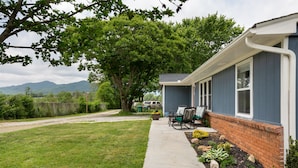 A house with a covered porch, a brick foundation, and a concrete pathway leading to the entrance. - country home minutes from downtown Asheville (Asheville)