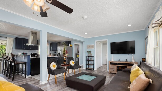 A modern living room with a sofa, a coffee table, and a TV. There is a kitchen in the background with a dining area. - country home minutes from downtown Asheville (Asheville)