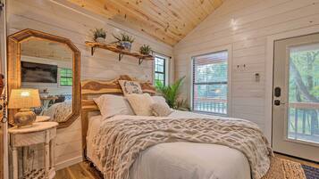 Cozy bedroom with a large bed, wooden headboard, and a bedside table with a lamp and mirror.