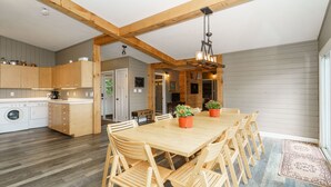 A spacious kitchen with wooden cabinets and a large dining table surrounded by chairs.